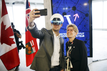Кетлін Вінн, експрем’єрка провінції Онтаріо, позує для селфі з чоловіком у VR-шоломі під час відкриття Vector Institute у Торонто, Онтаріо, Канада, 30 березня 2017 року.