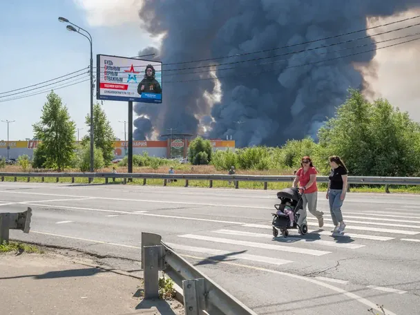 Російський пропагандистський білборд на тлі диму від удару / © Медуза